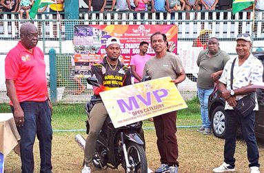 Quinten Sampson sits on the motorcycle he won for being MVP in the open category of the One Guyana Softball competition.