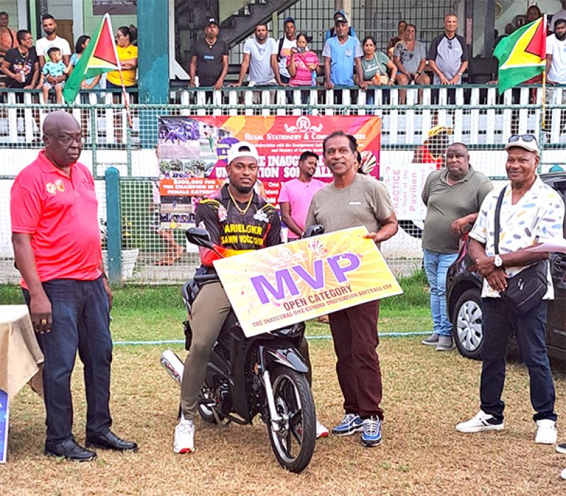 Quinten Sampson sits on the motorcycle he won for being MVP in the open category of the One Guyana Softball competition.