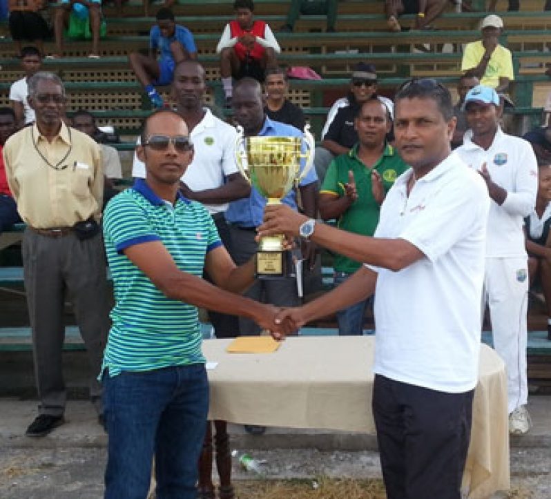 Congrats Cheesy! Captain of the victorious Demerara senior Inter-county team Vishaul ‘Cheesy’ Singh proudly uplifts the winners’ trophy and cheque from GCB secretary Anand Sanasie (right), while in background from left: Grantley Culbard, Rayon Griffith, Colin Stuart, Nazimul Drepaul and Shivnarine Chanderpaul share the moment.