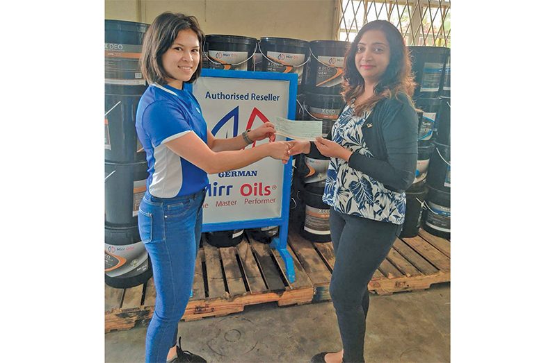 Ms. Sandra Prashad of Yellow Mines Hydraulics (left) hands over contribution to Ms. Fung-A-Fat.