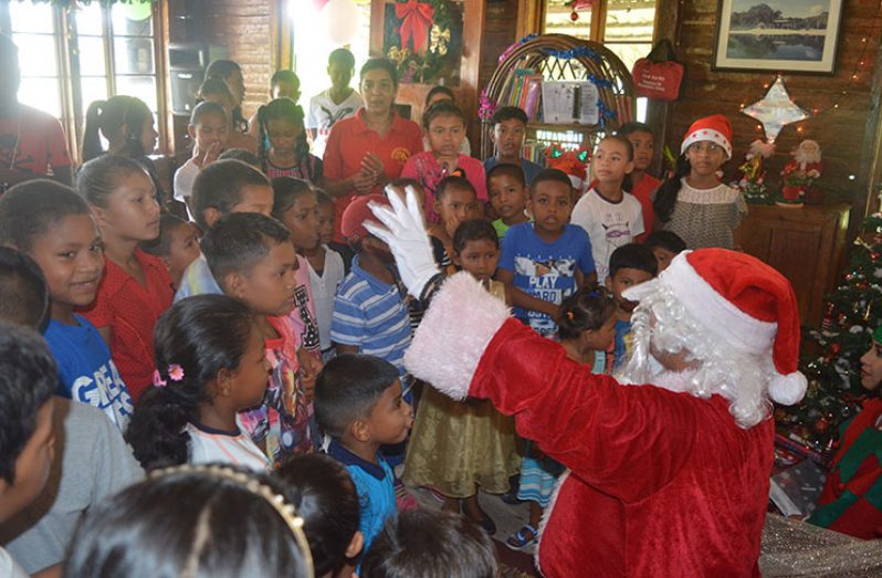 Santa Claus interacting with the children from Santa Mission before distributing gifts