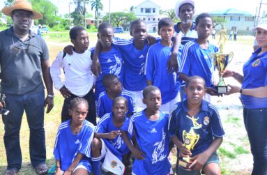 Ministry of Health’s Tamika Noel hands over the winner’s trophy to Santos ‘A’ Captain after yesterday’s Petra/Caribbean Wellness Day football tournament (Adrian Narine photo)