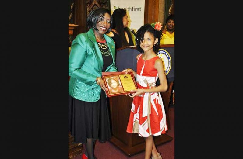 Sapphire Autumn Rose receives the ‘Golden Arrowhead of Achievement Youth Award of Achievement and Distinction’ from Guyana’s Consul General to New York the Hon. Barbara Atherly during Guyana’s 51st Independence anniversary celebrations at the Brooklyn Borough Hall, Brooklyn NY Friday