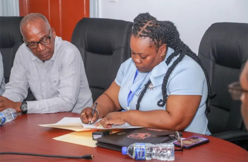 BIT’s CEO (ag), Saskia Eastman-Onwuzirike signing MoU in the presence of Labour Minister, Joseph Hamilton