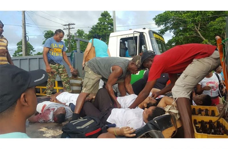 Public-spirited citizens assisting the injured persons out of the minibus to be taken to the hospital