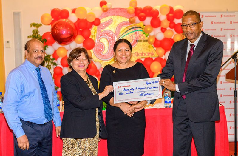 Scotiabank Country Manager  Raymond Smith presents Dr Paloma Mohamed,Deputy Vice-Chancellor  for Philanthropy, Alumni and Civic Engagement with a cheque for $2M to construct a smart-classroom at the university  as  Canadian High Commissioner to Guyana   Lilian Chatterjee (second left)  and Central Bank Governor,Dr Gobind Ganga,look on. (Delano Williams photo)