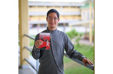 Scott alongside his book 'Red Hibiscus' published in 2018, Red Hibiscus shows Chinese indentureship through a unique perspective (Samuel Maughn photo)