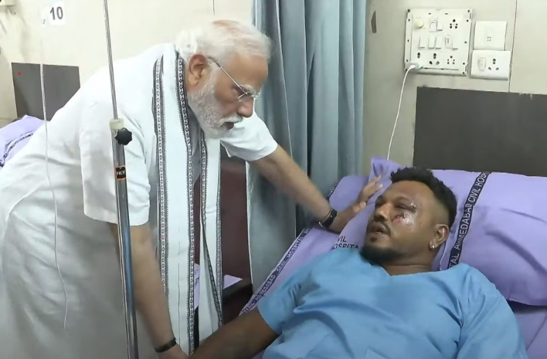 This screengrab of video footage taken and released by the Narendra Modi Youtube Channel on June 13, 2025 shows India's Prime Minister Narendra Modi (L) meeting with Vishwash Kumar Ramesh, sole survivor of the Air India flight 171 crash, at a hospital in Ahmedabad.