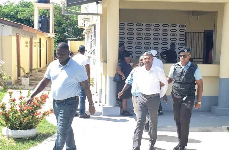 Seeindra Marimutoo being escorted by police to face the charge of murder