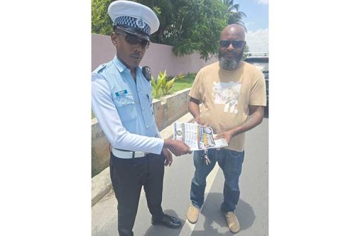 A traffic rank shares out educational materials during an interaction with a driver during a recent outreach