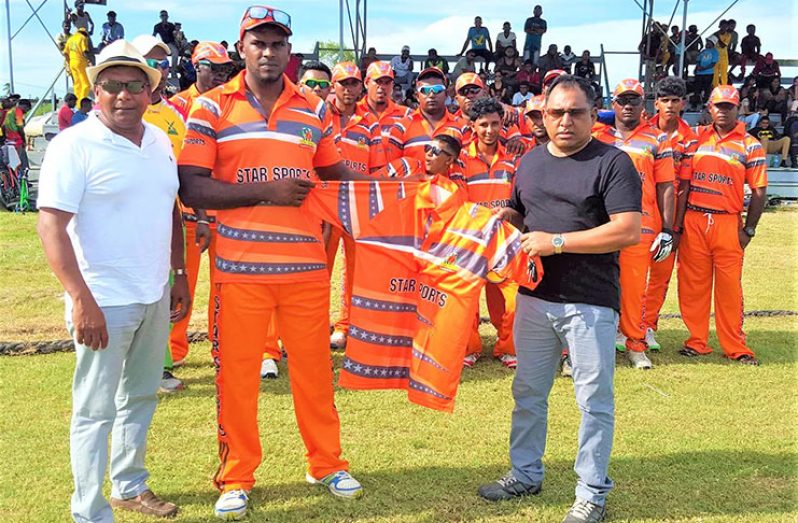 Sheik Mohamed (right) of Star Sports presents the uniforms to Roshan Gaffoor in the presence of overseas-based Guyanese and cricket enthusiast Bruce Deoraj.