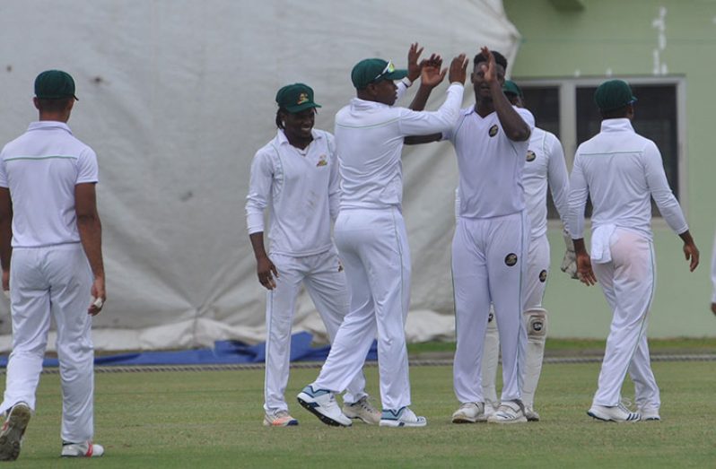 Fast bowler Romario Shepherd celebrates with teammates after he initiated the demolition.