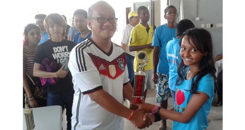 Sheriffa Ali collects her first place trophy after she won the level three (Bishop) category in the Loper Klasse Open Rapid 2014 competition in Suriname last Sunday.