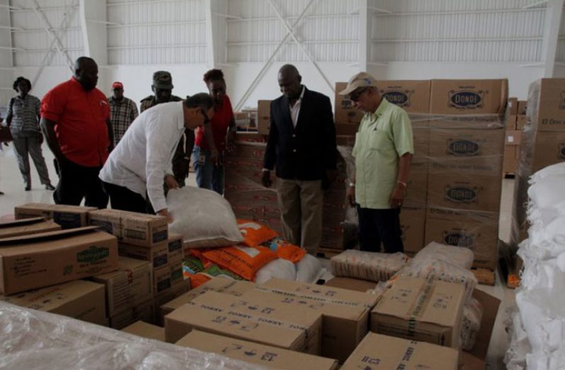 Minister of Citizenship, Mr Winston Felix (second right), along with the CDC’s Major Sean Welcome (right) and island officials inspecting the first wave of relief supplies on arrival Sunday (Photo courtesy DPI)