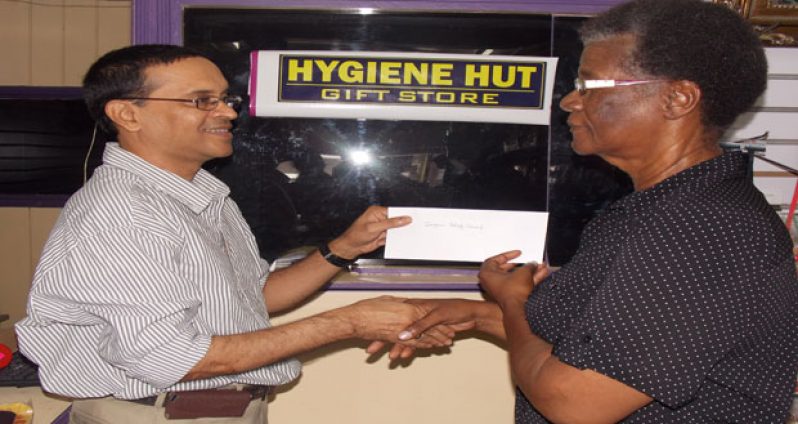 Hygiene Hut’s Managing Director Shiv Nandalall presents a cheque to Administrative Officer of the Guyana Relief Council, Lynette Carter