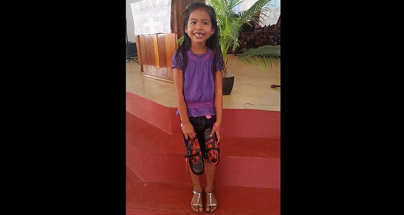 A schoolgirl from Charity beams with joy after receiving a new pair of shoes