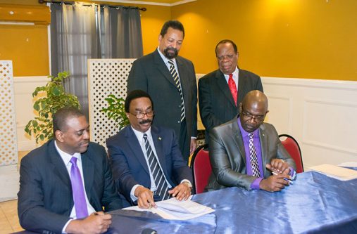 Attorney General (AG) and Minister of Legal Affairs, Basil Williams SC, signs the Memorandum of Understanding (MoU) to bring into effect formal arrangements to commence  establishment of the law school. He is flanked by Mr. Courtney Wynter (left), Chairman, Law College of the Americas (LCA); Dr Winston Adams, Group Executive Chairman, University College of the Caribbean (UCC); (standing from left) Professor Dennis Gayle, Executive Chancellor, UCC; and Dr Trevor Hamilton, Advisor on the law school venture