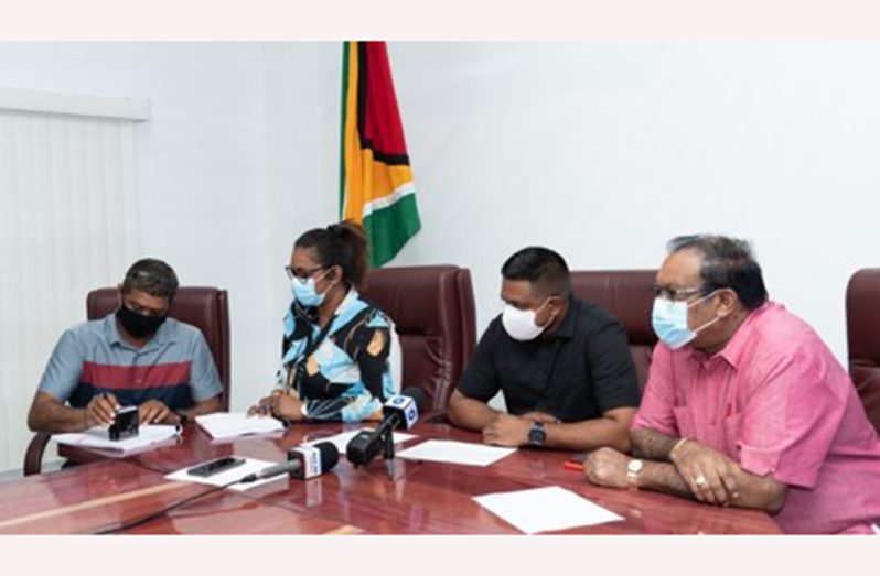 Ministry of Local Government and Regional Development, Permanent Secretary, Prema Ramanah-Roopnarine (left); Minister of Local Government and Regional Development, Nigel Dharamlall (centre) and Minister within the Ministry of Local Government and Regional Development, Anand Persaud (right) look on as a contractor sign his contract