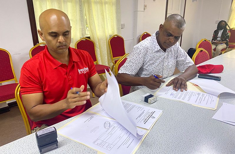 Adel Baksh from Imam Bacchus and Sons signing his contract. Also in the photo is Mr Ramballi from Ramballi construction
