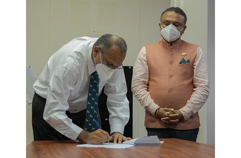 Health Minister, Dr. Frank Anthony signs an agreement that will see the disbursement of funds to strengthen Guyana’s response to the COVID-19 pandemic as India’s High Commissioner, Dr K.J. Srinivasa, looks on