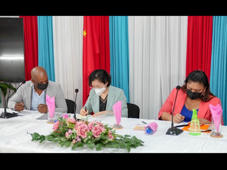 Guyana Table Tennis Association president, Godfrey Munroe (left), looks on as Ambassador Guo Haiyan (centre) and Minister of Education, Priya Manickchand,  sign the agreements yesterday