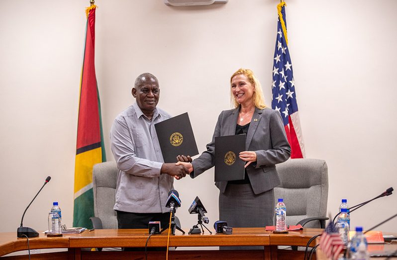 US Ambassador to Guyana Nicole Theriot and Home Affairs Minister Robeson Benn at Monday’s signing ceremony (DPI photo)