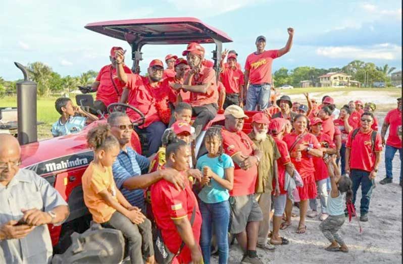 President Dr. Mohamed Irfaan Ali enjoying a light moment with residents of Silver Hill along the Soesdyke-Linden Highway on Tuesday
