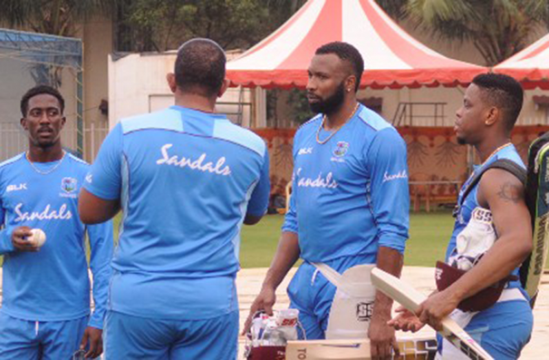 TALKING STRATEGY: Captain Kieron Pollard (second from right) chats with head coach Phil Simmons (backing camera) as Hayden Walsh (left) and Shimron Hetmyer listen in. (Photo courtesy CWI Media)