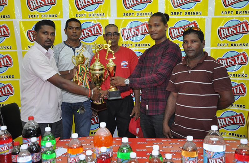RHTY&SC MS Asst Secretary Simon Naidu hands over trophies to Lloyd Murray of Skeldon CC.