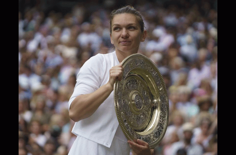 Romania's Simona Halep poses with the trophy as she celebrates after winning the final against Serena Williams of the U.S. at Wimbledon All England Lawn Tennis and Croquet Club, Britain.  (REUTERS/Hannah McKay)
