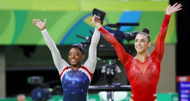 Simone Biles (USA) (L) and Alexandra (Aly) Raisman (USA) celebrate winning gold and silver respectively. (Reuters/Mike Blake)