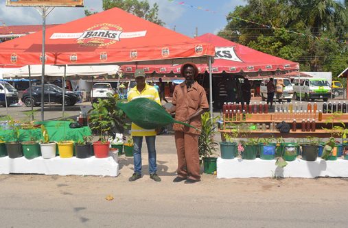Dr. Simpson Da Silva  (left) and a colleague showcasing their plants at the Linden/Georgetown Bus Park