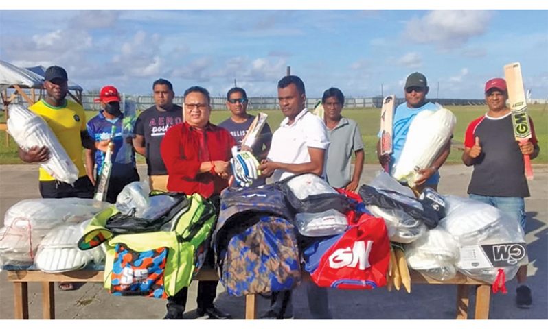 GCB president Bissoondyal Singh presents the donation, in the form of cricket gear, to the president and members of the WDCA