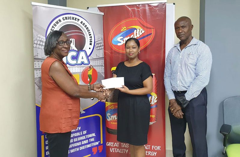 Marketing Manager of GBI, Melinda Telesford hands over cheque to Programme manager, Deborah McNichols, in the presence of GCA president Neil Barry Sr on Tuesday