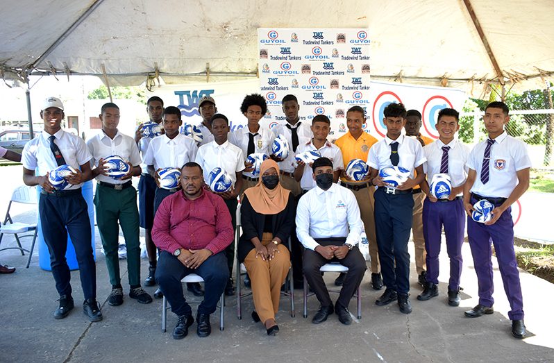 Students and teachers pose with their soccer balls as PETRA president Troy Mendonca (from left sitting) is flanked by representatives of GUYOIL and Guyana Tradewind Tankers. (Carl Croker photo)
