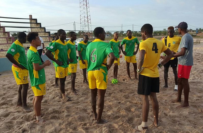 Head Coach Adbulla Hamid converses with his squad during a training session at the Bayrock Beach Facility in Linden