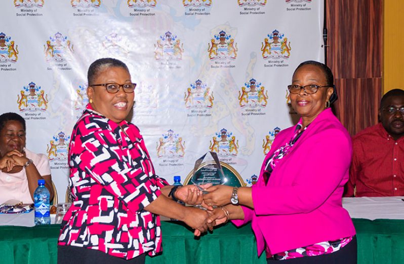 Director of the Child Protection Agency, Ann Greene (left), receiving an award on behalf of a colleague, moments before receiving hers for outstanding social work