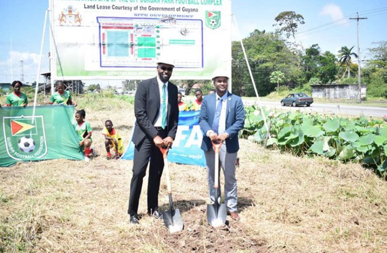Director of Sport Christopher Jones and president of the GFF, Wayne Forde, turn the sod where the football complex will be built.