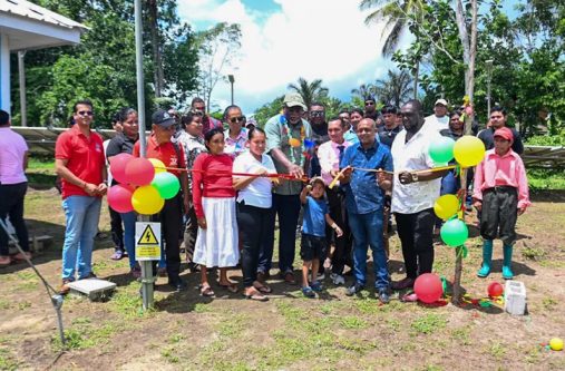 Prime Minister, Brigadier (Ret’d) Mark Phillips, cuts the ribbon with residents of Sebai, Matarkai Sub-district, Region One, to commission the Solar Photovoltaic Mini-Grid System in the community