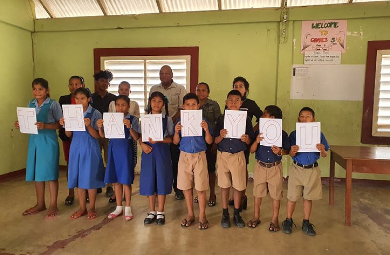 Minister of Natural Resources, Raphael Trotman, with pupils and teachers of the primary school at Parikwarinau