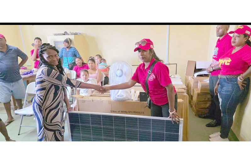 A resident of Good Hope Sea Dam receives her solar panel system