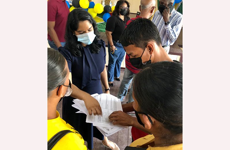 Minister Parag assisting one resident with her application form