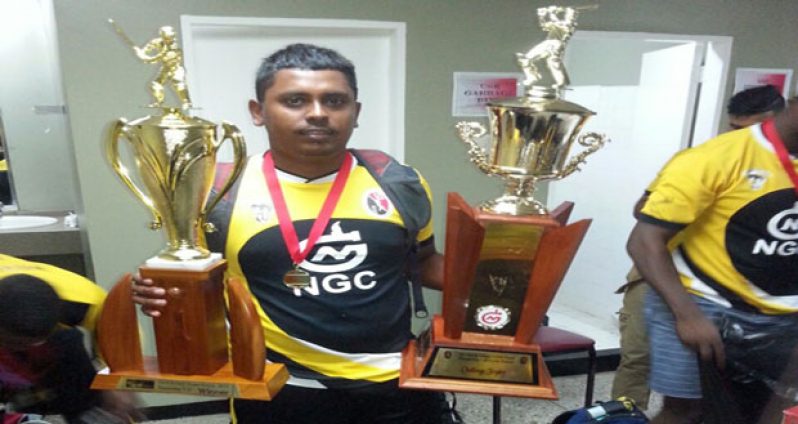 Merry Boys’ Jeetendra Sookdeo proudly displays the TTCB/NGC T20 championship trophy (left hand) and the replica which will be on display in Merry Boys’ cabinet.