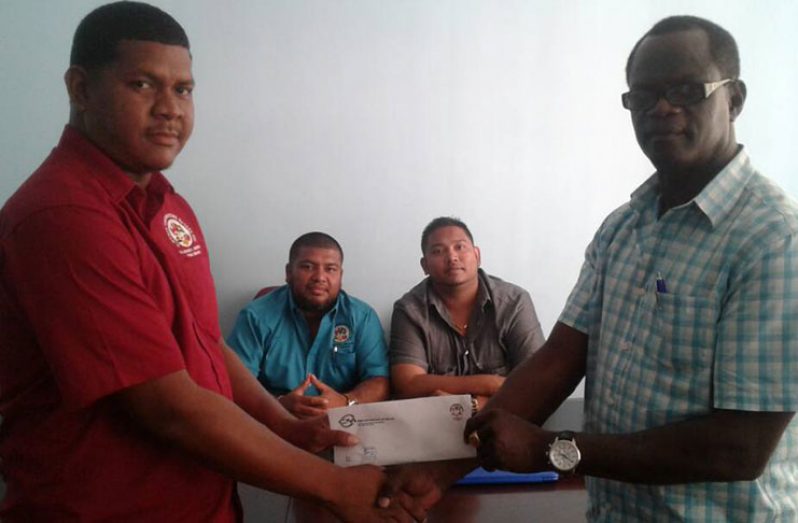 Office Manager, Bevaughn Ferrier (left) of C. Mohan Contracting Guyana Inc., hands over the sponsorship to chairman of Boyce and Jefford committee, Colin Boyce, as proprietors Carl Methuram (foreground, left) and Vishal Mohan look on