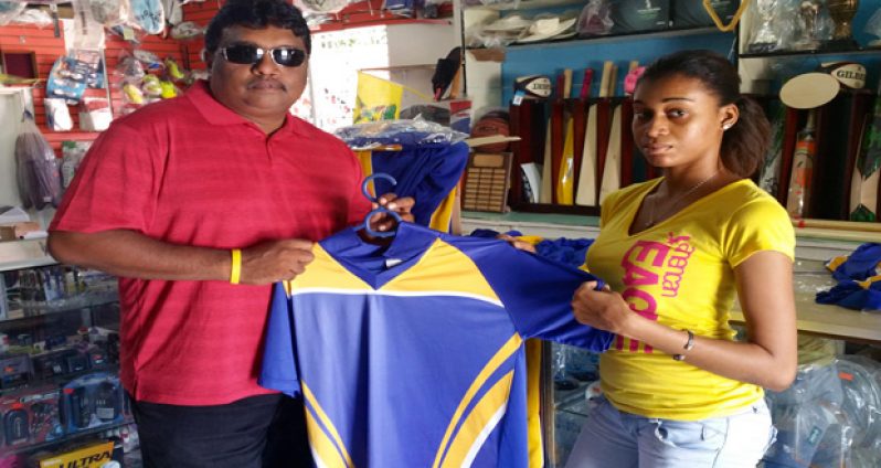 Marcia Shanks, right, a representative of Mike's Pharmacy hands over one set of uniforms to YWCC secretary/treasurer.