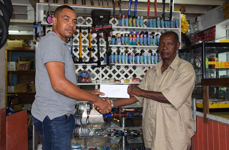 Proprietor of Jude Bike Shop, Jude Bentley (left) hands over the sponsorship to representative of the Boyce & Jefford Committee, Claude Bennett, at the Robb Street location of the business.