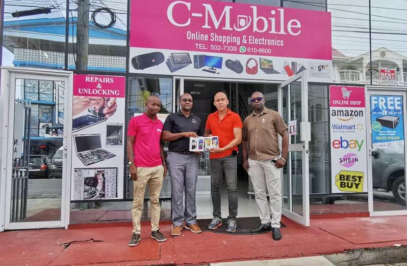 CEO of C-Mobile Online Shopping & Electronics Chris Low Koan (2nd right) hands over the phones to GFF president Wayne Forde. At right is Aubrey ‘Shanghai’ Major and left, Orande Gittens.