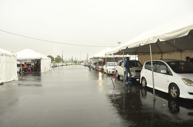 Long lines of vehicles backed up at the National Stadium, Providence, East Bank of Demerara, on Wednesday, as scores of persons turned up at the ‘drive thru’ vaccination site to be administered their COVID-19 ‘jab’ (Adrian Narine Photo)