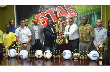 EDFA General Secretary Franklin Wilson collects the tournament’s first place trophy from Ansa McAl’s Marketing Director Troy Cadogan while other stakeholders of the game look on.