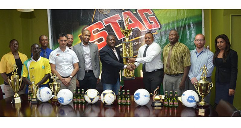 EDFA General Secretary Franklin Wilson collects the tournament’s first place trophy from Ansa McAl’s Marketing Director Troy Cadogan while other stakeholders of the game look on.
